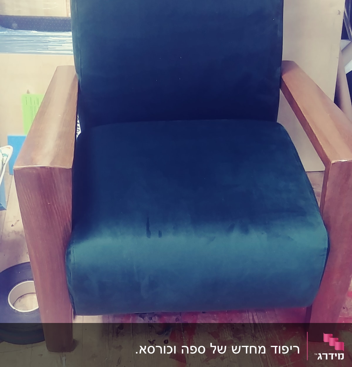 כורסה מרופדת בבד ירוק כהה עם מסגרת עץ